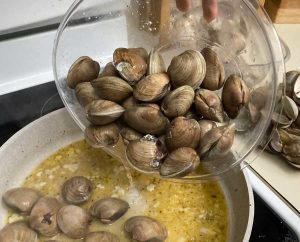 Adding clams to pan